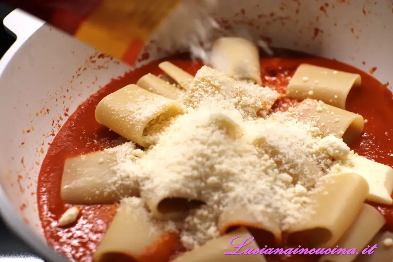Paccheri alla Vittorio, un piatto ricco di sapore con pasta, sugo rosso e abbondante parmigiano grattugiato.