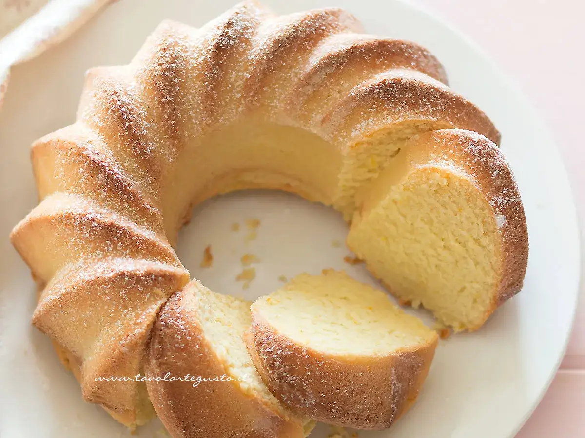 Una soffice torta ricotta veloce, spolverata di zucchero a velo, con una fetta tagliata.